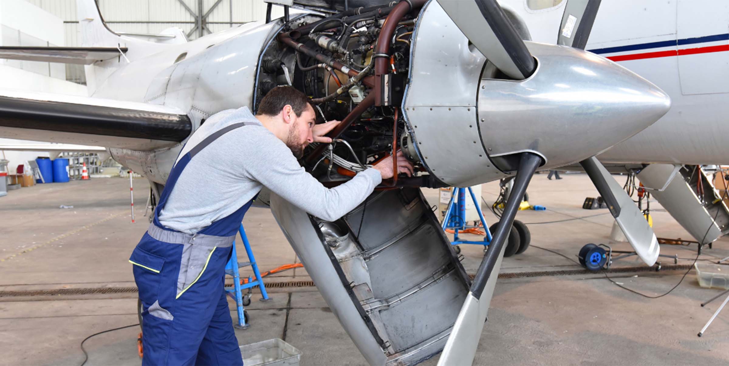 Small Aircraft Engine Maintenance by Mechanic in Hangar